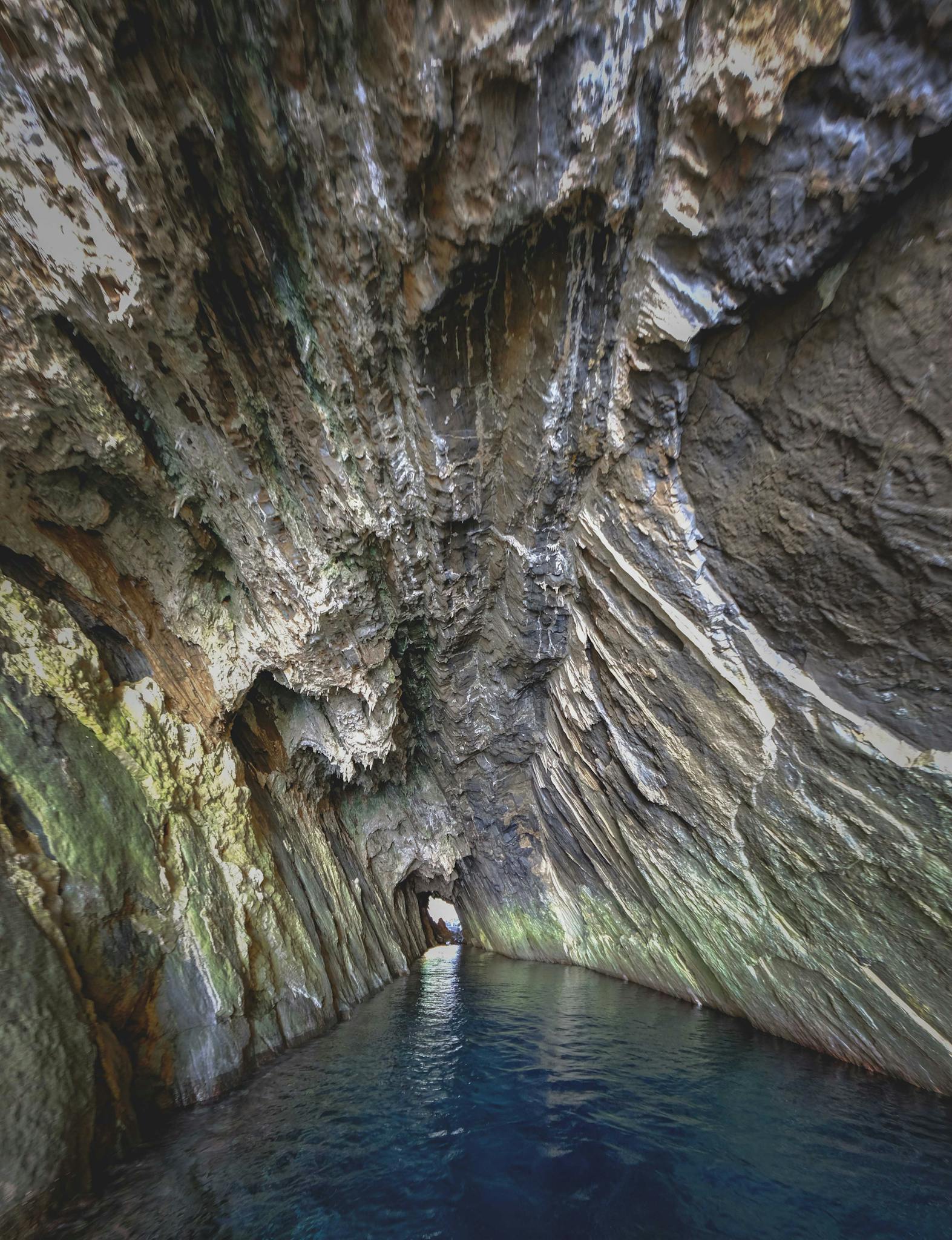 Explore the beauty of a natural ocean cave with striking rock formations and tranquil waters.